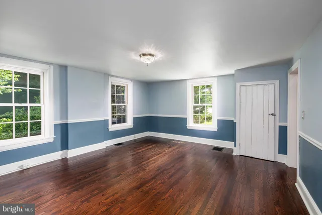 a backyard of a house with plants and wooden fence