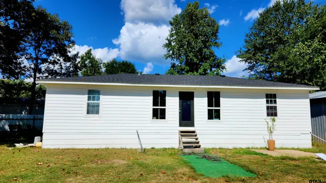 a view of a white house with a yard