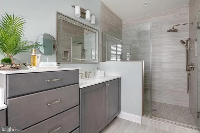 a bathroom with a double vanity sink mirror and shower