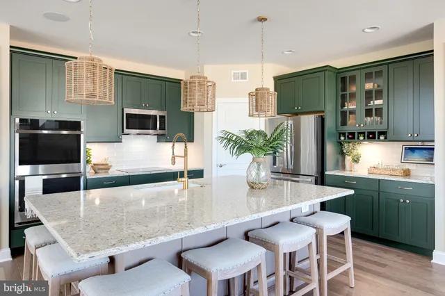 a large kitchen with granite countertop a counter space a sink stainless steel appliances and cabinets