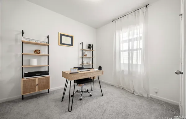 a view of a workspace with furniture and a window