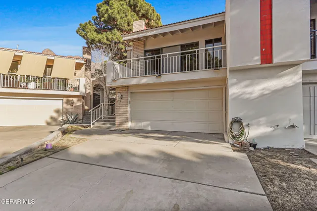 a front view of a house with barbeque oven and seating space