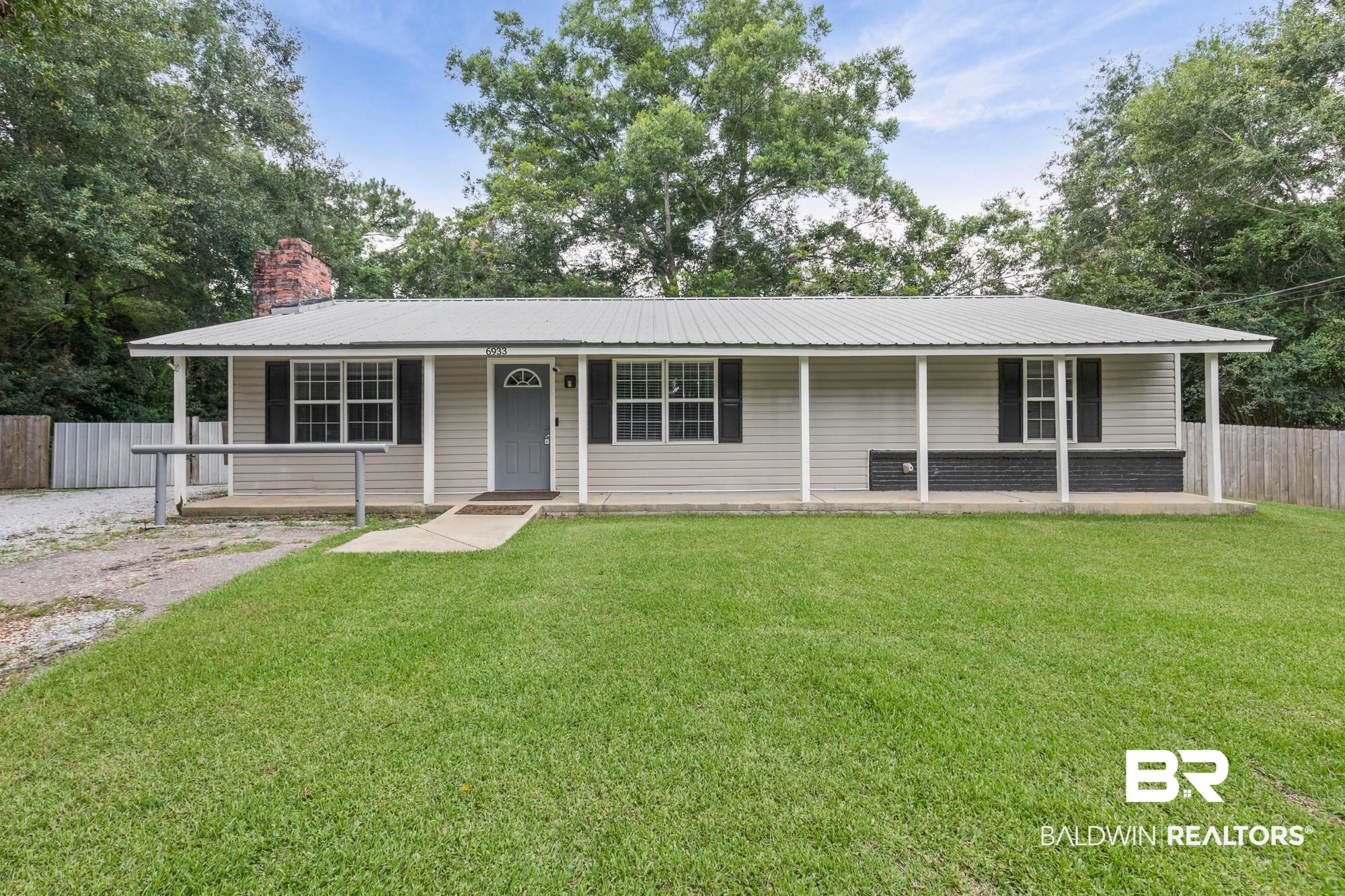6933 Burbank Court Mobile, AL 36619 - Photo 1 of 25 Single-story residence featuring light-toned siding, a covered front porch, and a metal roof