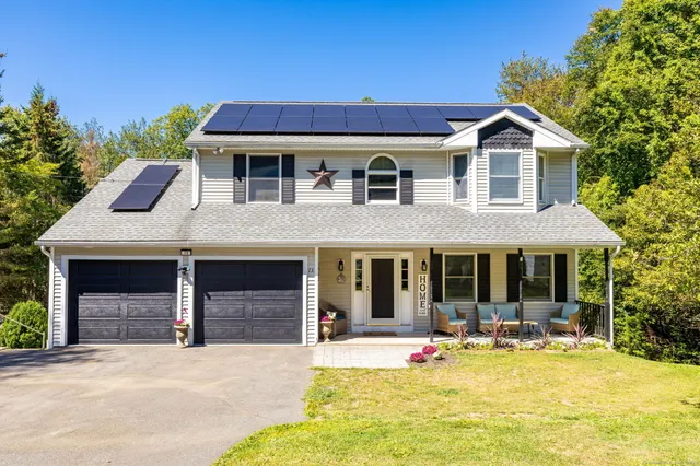a front view of a house with swimming pool and furniture