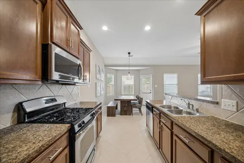 a large kitchen with granite countertop a sink and a stove top oven