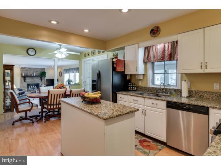 21 Fairview Road Medford, NJ 08055 - Photo 7 of 25 a kitchen with stainless steel appliances granite countertop a sink dishwasher a stove a dining table and chairs with wooden floor
