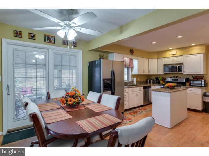 21 Fairview Road Medford, NJ 08055 - Photo 8 of 25 a kitchen with stainless steel appliances kitchen island granite countertop a dining table chairs and a refrigerator