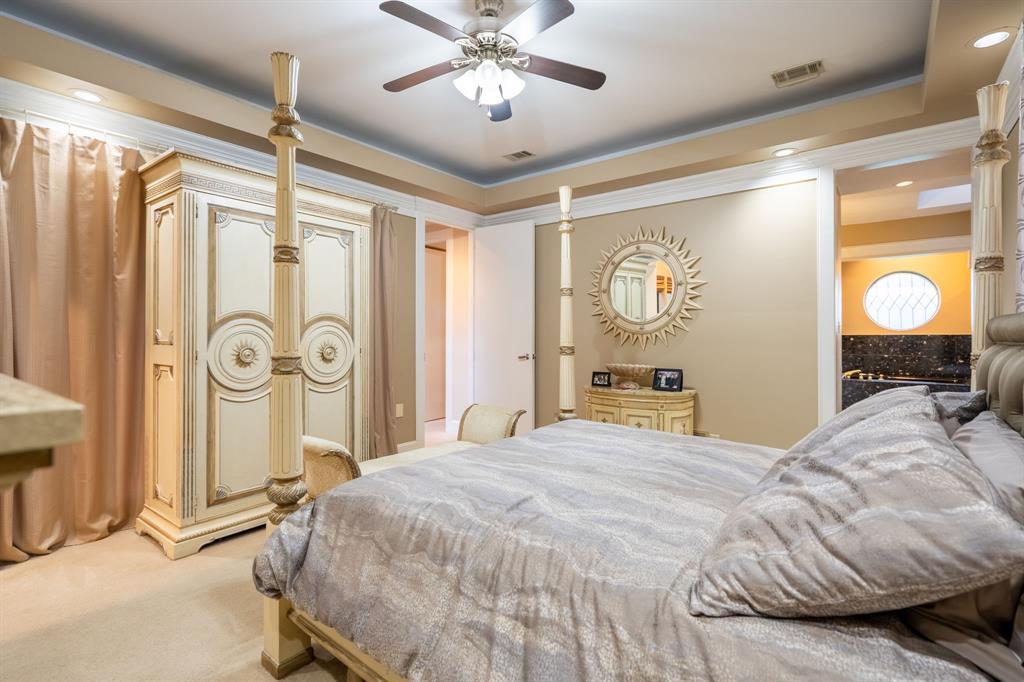 1450 Meandering Way Rockwall, TX 75087 - Photo 18 of 32 a bedroom with a bed and a chandelier