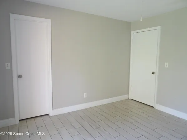 a view of an empty room with wooden floor
