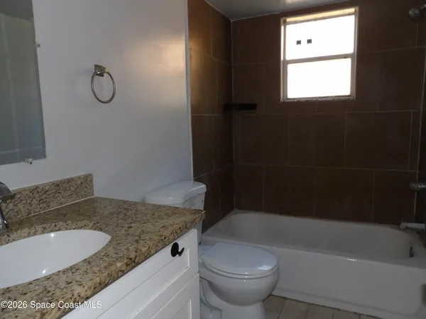a bathroom with a granite countertop sink toilet and bathtub