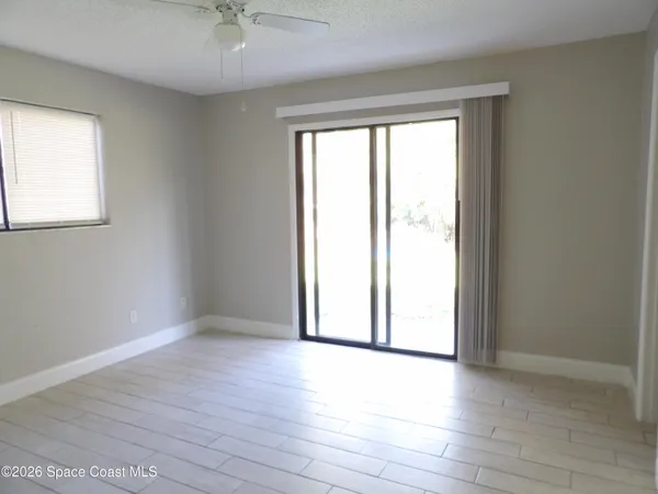 an empty room with wooden floor and windows