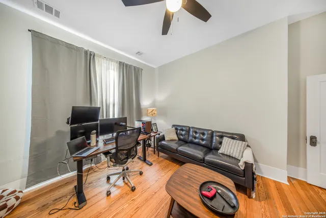 a living room with furniture and a wooden floor