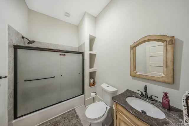 a bathroom with a granite countertop sink toilet and shower