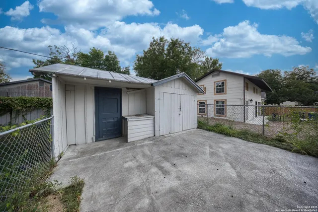 a view of a house with a yard and fence