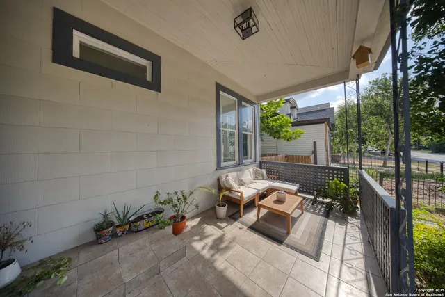 a view of a patio with table and chairs potted plants with wooden floor and fence