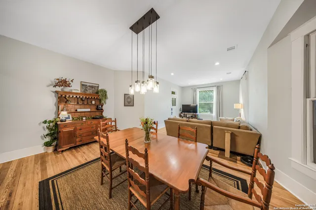 a dining room with furniture a chandelier and wooden floor