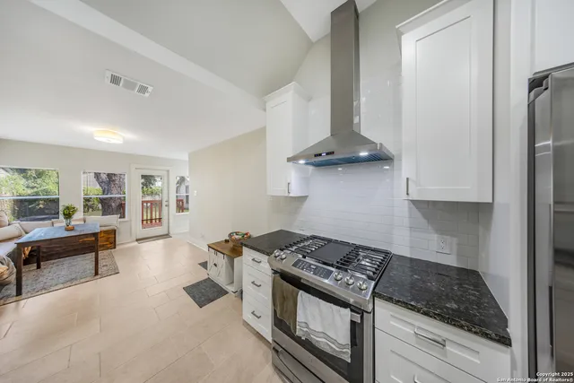 a kitchen with stainless steel appliances granite countertop a stove and a refrigerator