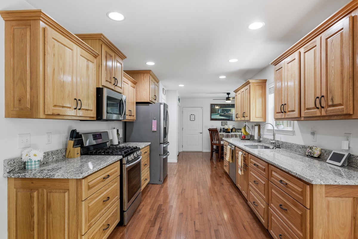1555 Heller Ridge Spring Hill, TN 37174 - Photo 14 of 50 a kitchen with stainless steel appliances granite countertop a stove top oven a sink dishwasher a refrigerator and a cabinets with wooden floor