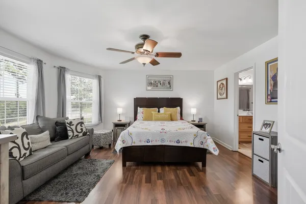 a bed room with a bed couch and a chandelier