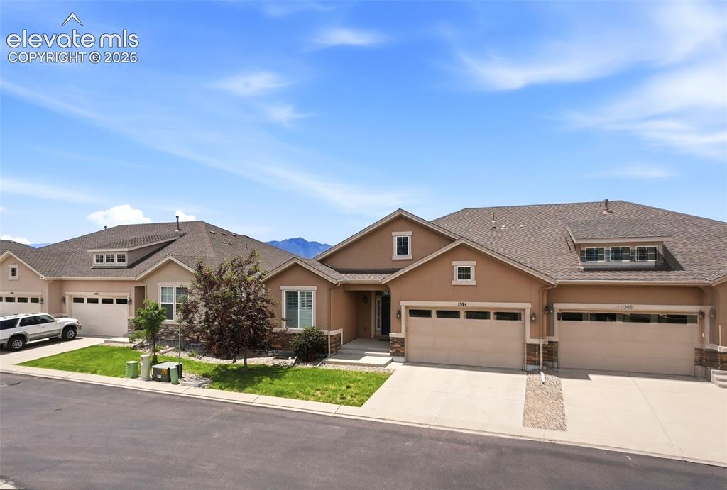 1394 Promontory Bluff View Colorado Springs, CO 80921 - Photo 2 of 47 a front view of a house with a garden and parking