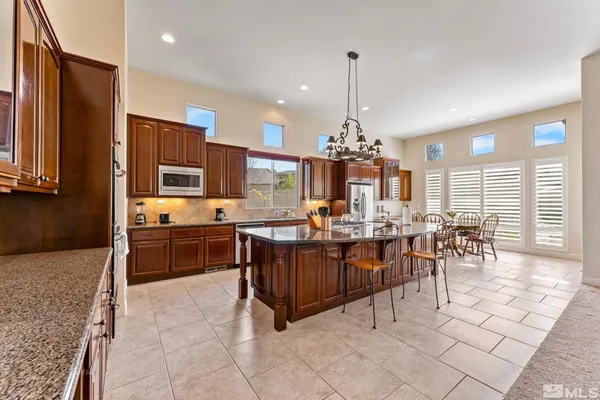 a very nice looking kitchen with granite countertop a stove and cabinets