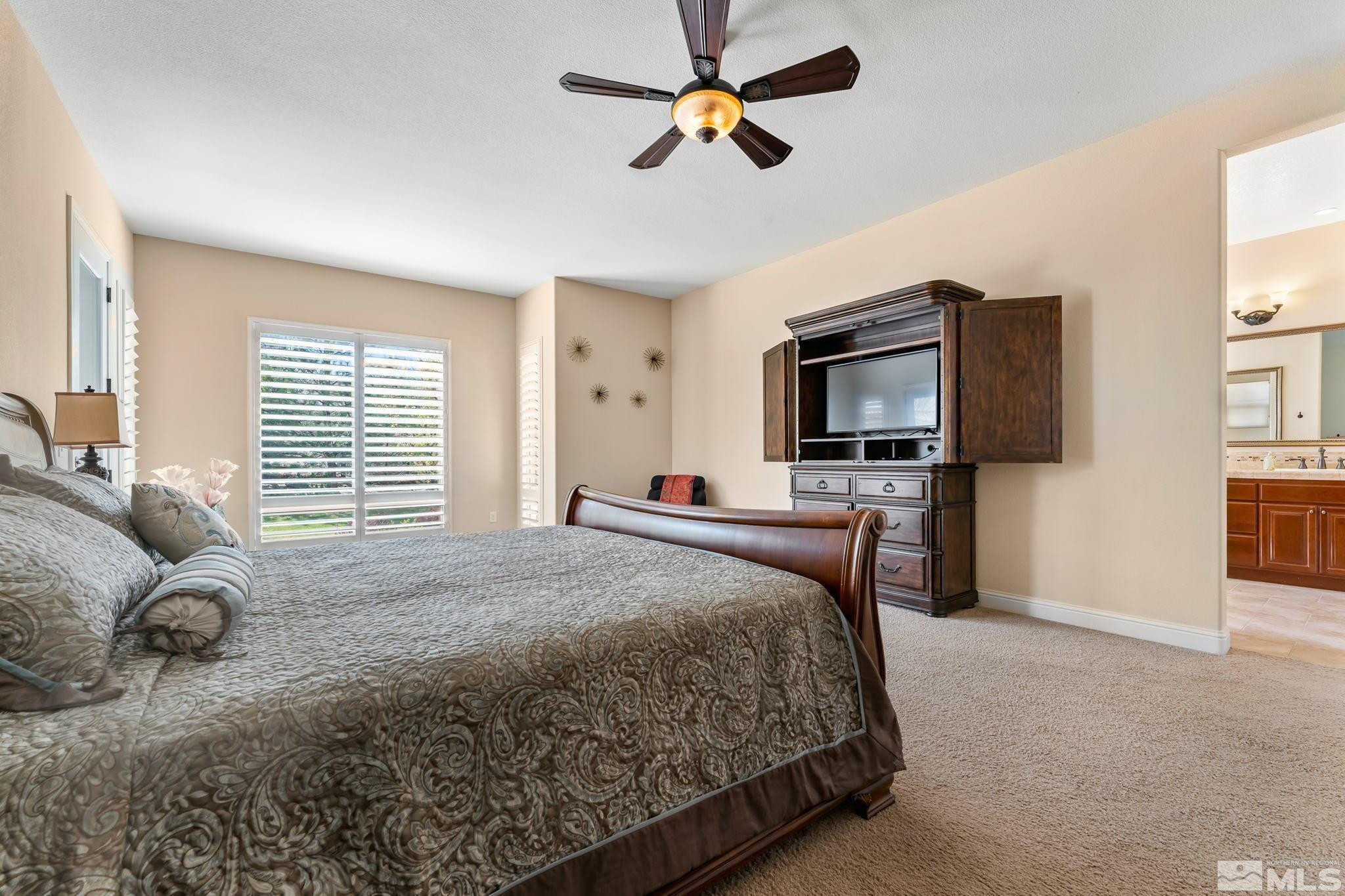 13395 Damonte View Lane Reno, NV 89511 - Photo 21 of 40 a bedroom with a bed a flat screen tv and a couch