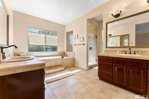 a spacious bathroom with a tub sink and mirror