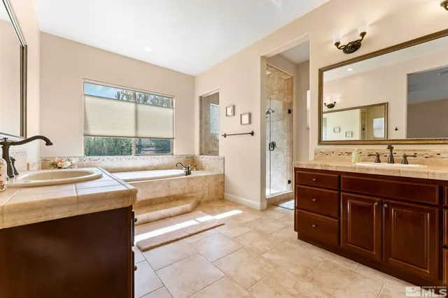 a spacious bathroom with a tub sink and mirror