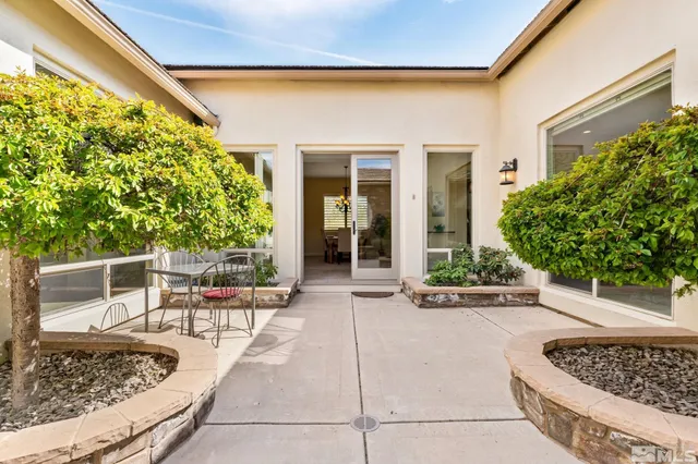 a view of a patio with table and chairs and potted plants