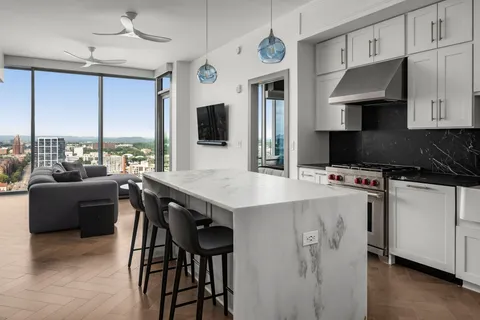 a kitchen with stainless steel appliances a table chairs refrigerator and microwave