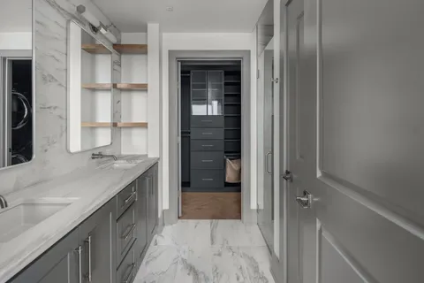 a bathroom with a granite countertop sink a mirror and a shower
