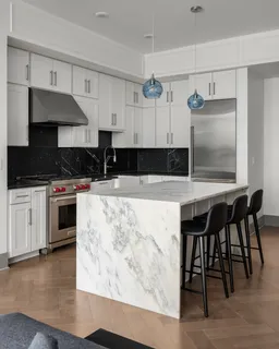 a kitchen with granite countertop a stove a sink and a microwave