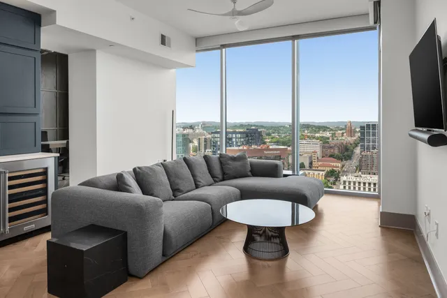 a living room with furniture a rug and a large window