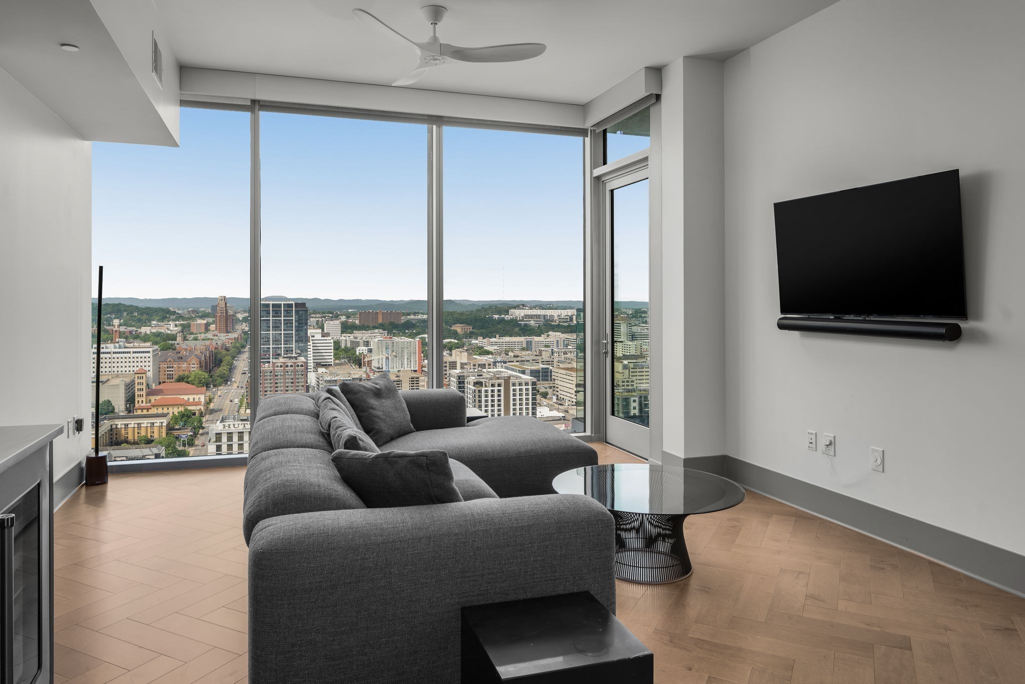 1616 West End Avenue, Unit 2609 Nashville, TN 37203 - Photo 10 of 46 a living room with furniture a flat screen tv and a floor to ceiling window