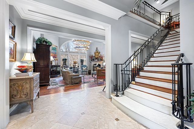 a living room with a bed and chandelier