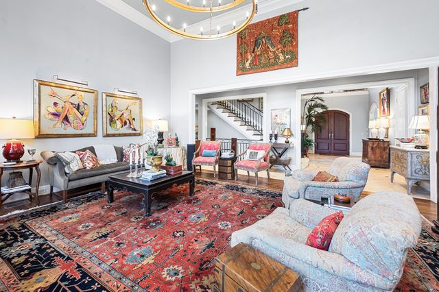 a spacious bedroom with a bed a chandelier and a couch
