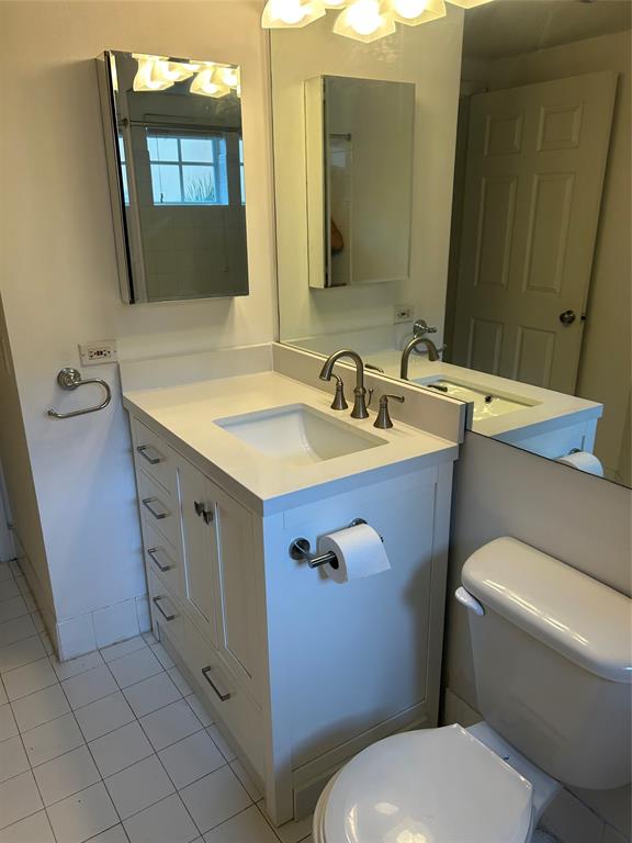 17150 North Bay Road, Unit 2519 Sunny Isles Beach, FL 33160 - Photo 6 of 9 a bathroom with a granite countertop toilet sink and mirror