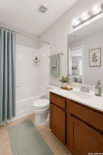 a bathroom with a double vanity sink toilet and shower