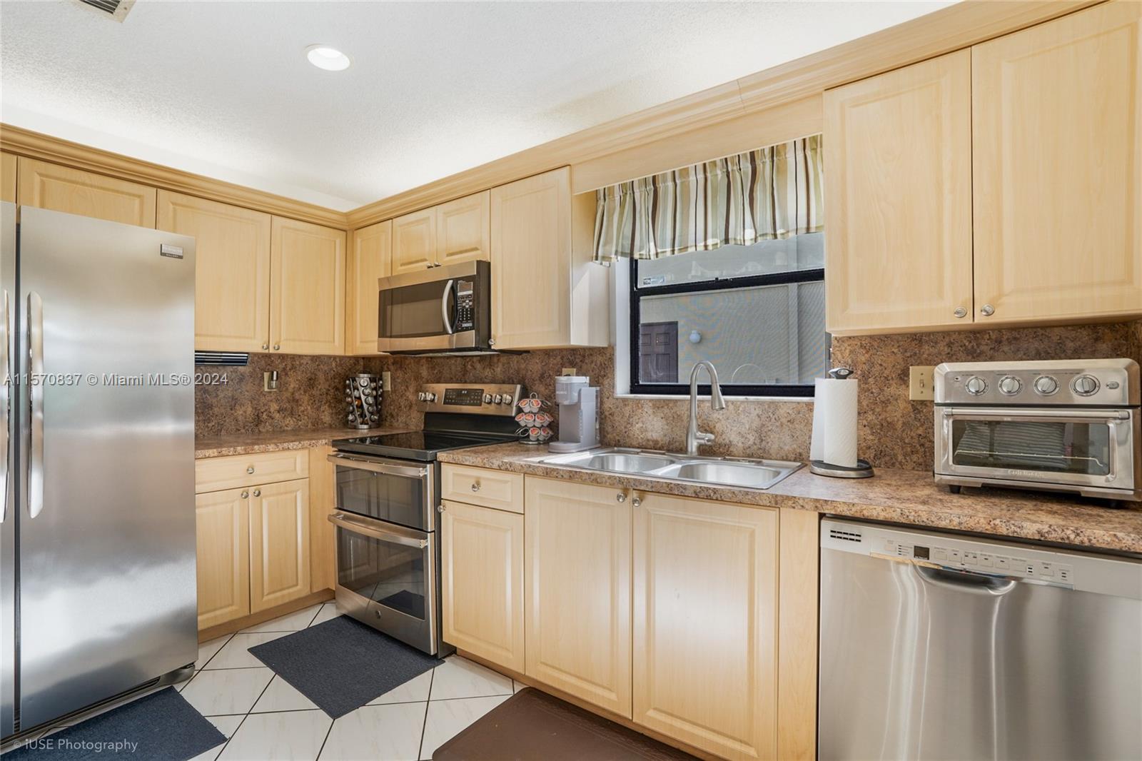 15440 Gauntlet Hall Manor Davie, FL 33331 - Photo 7 of 18 a kitchen with stainless steel appliances granite countertop a stove a sink and a refrigerator