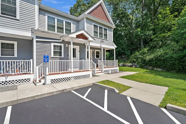 a front view of a house with a yard porch and wooden fence