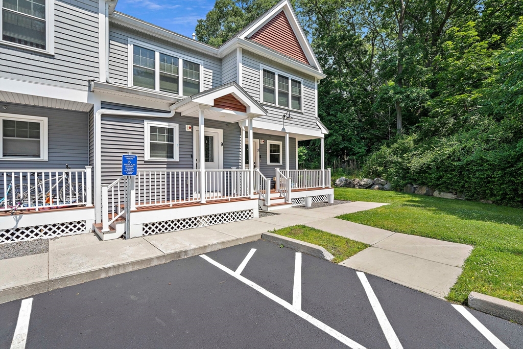 a front view of a house with a yard porch and wooden fence