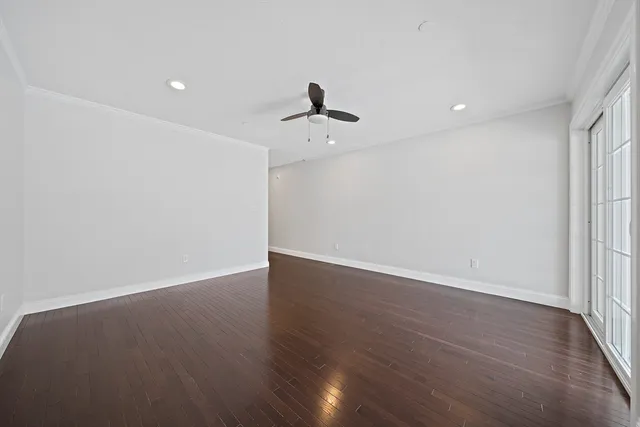 a view of a room with wooden floor and a ceiling fan