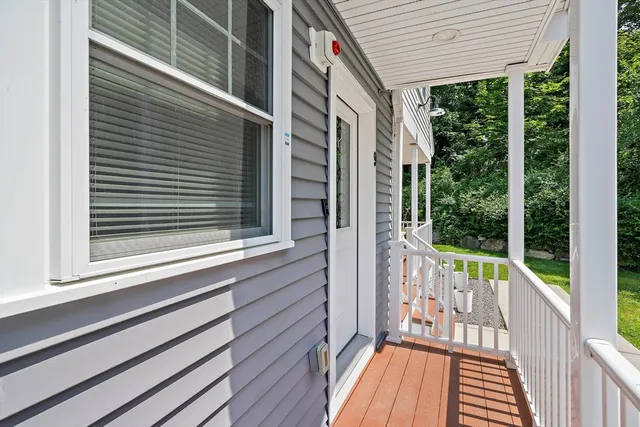 a view of a balcony with wooden floor and iron stairs