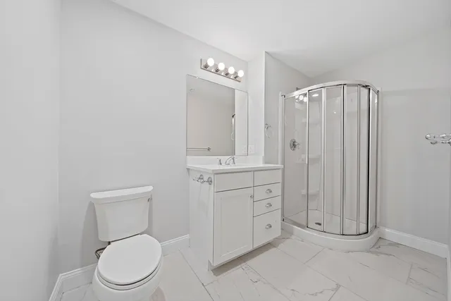 a bathroom with a toilet a sink and mirror