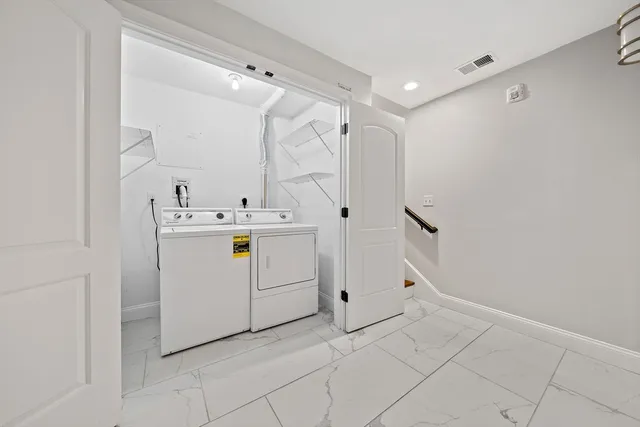 a utility room with cabinets washer and dryer