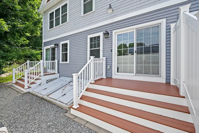 a view of a house with a small yard and wooden floor and fence