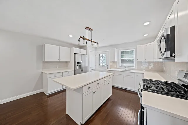 a kitchen with white cabinets and white appliances