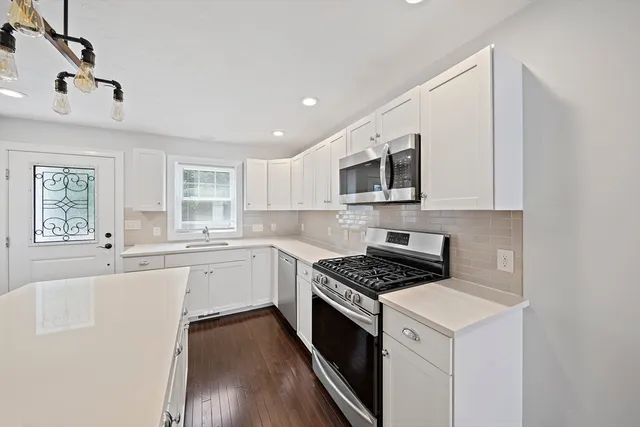 a kitchen with granite countertop a stove top oven sink and cabinets