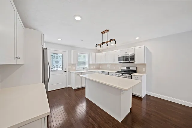 a kitchen with white cabinets and appliances