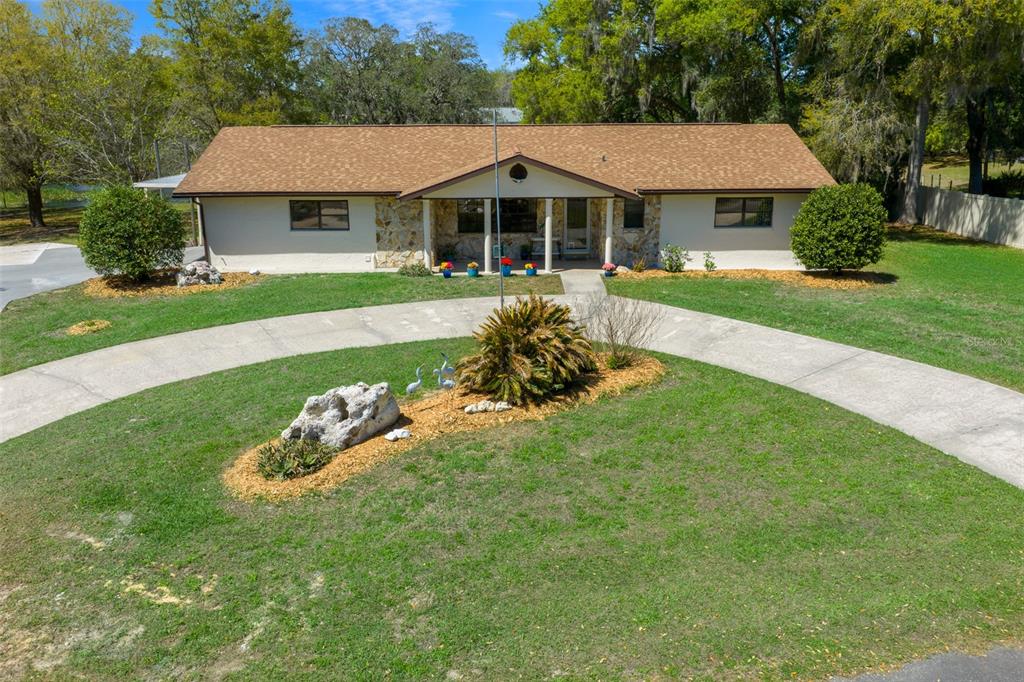 9923 East St Regis Court Inverness, FL 34450 - Photo 14 of 76 a front view of a house with a yard table and chairs